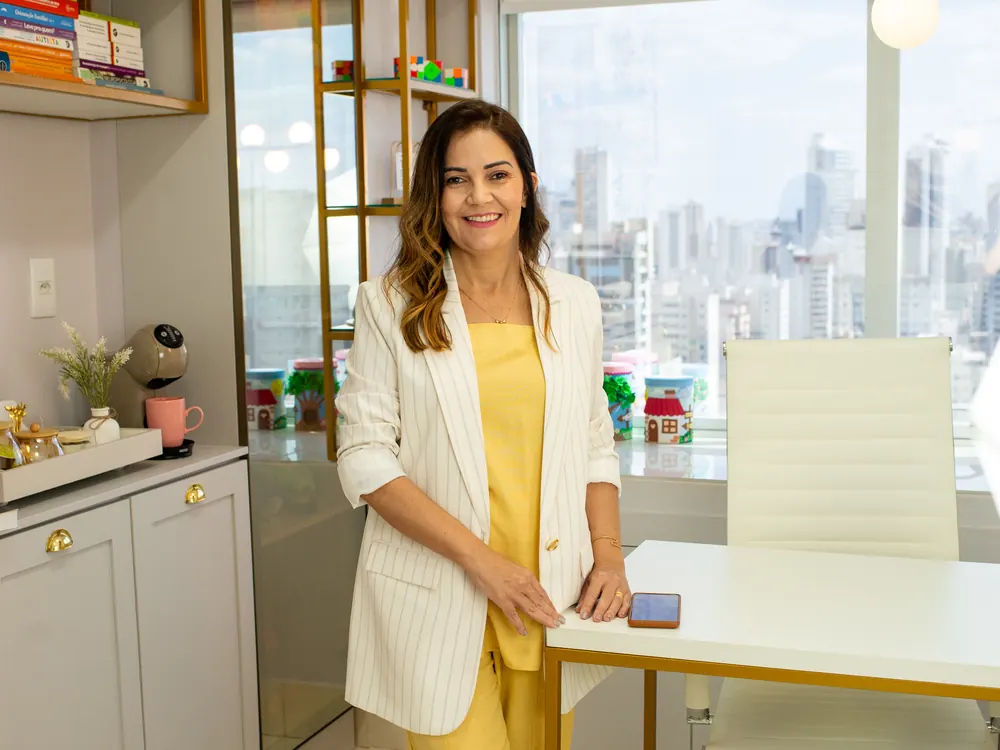 Gracielle Dourado na sala de atendimento da Acolher Infância, com vista para Goiânia